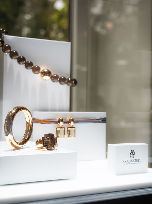 vitrine-mit-rotgold-armreif-plus-ring-ohrringe-mit-einhänger-auffälliger-schmuck_citrin-ohrringe_brauksiepe-goldschmiedemanufaktur-juwelier-essen-goldschmiede-essen